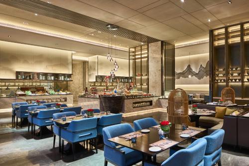 ShangraoにあるWanda Realm Shangraoの青い椅子とテーブルのあるレストラン、バー
