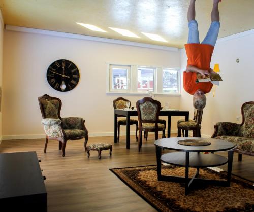 a person is upside down on the ceiling in a living room at Radailiu Dvaras - Dinosaur Park in Radailiai