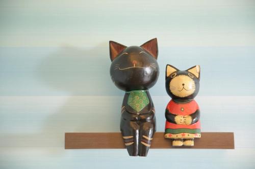 two wooden cat figurines sitting on a shelf at Beachcastle & Sea View Villa in Magong