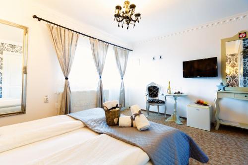 a bedroom with a large bed with two towels at Pensiunea Avy in Haţeg