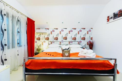 a bedroom with a bed with a red blanket at Pensiunea Avy in Haţeg