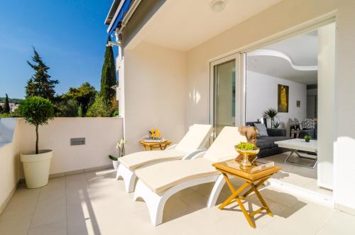a living room with white furniture and a large window at Magellan Deluxe One in Dubrovnik