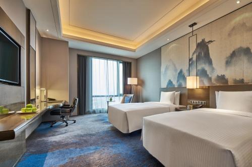 A bed or beds in a room at Wanda Realm Shangrao