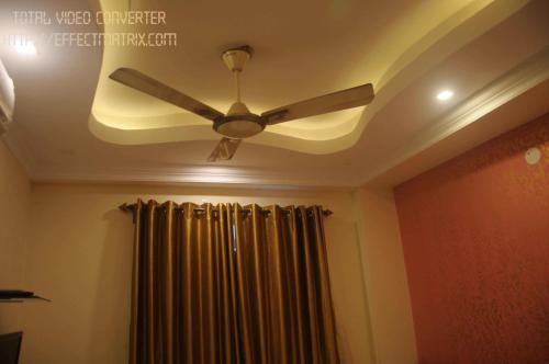 a ceiling fan in a room with a curtain at Golden Heaven Hotel in Kolkata