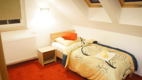 a small bedroom with a bed and a table at Dom przy Basenie in Puck