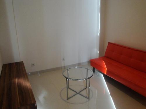 a red couch and a table in a room at Hotel on The Rock in Kupang