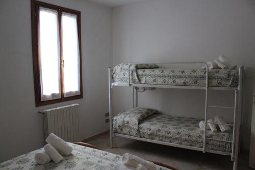 カステルフィオレンティーノにあるCasa Tafiの二段ベッド2台と窓が備わる客室です。
