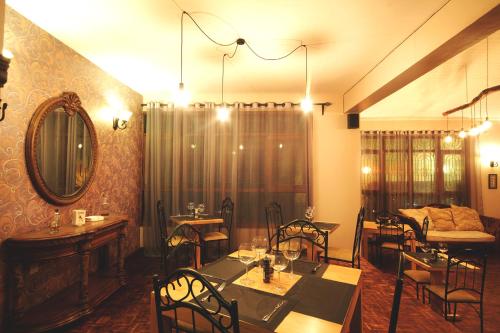 a dining room with a table and chairs and a mirror at Boulevard Inn Mt Meru in Arusha