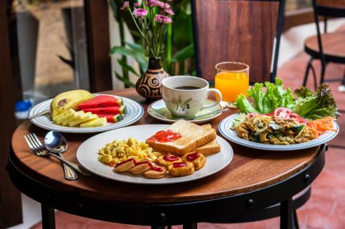 i Lanna House في شيانغ ماي: طاولة مع أطباق من الطعام وكوب من القهوة