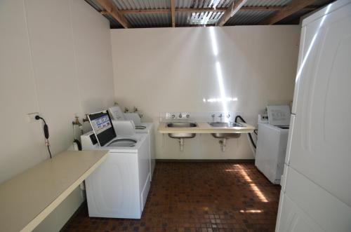 a white bathroom with a sink and a counter at Coalmine Beach Holiday Park in Walpole