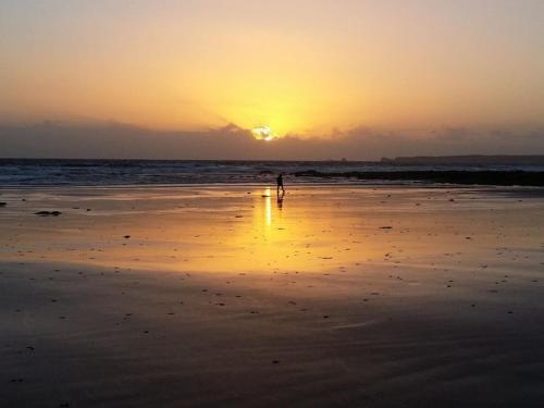 a person walking on the beach at sunset at Island Daze Surf Beach Phillip Island in Phillip Island