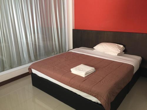 a bed with two towels on it in a room at Shanghai Guesthouse Monna bar in Pattaya Central