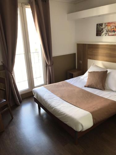 a bedroom with a large bed and two windows at Grand Hotel Nouvel Opera in Paris