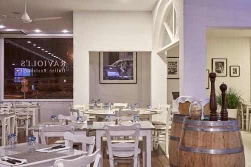a restaurant with white tables and white chairs at Grecian Park in Protaras