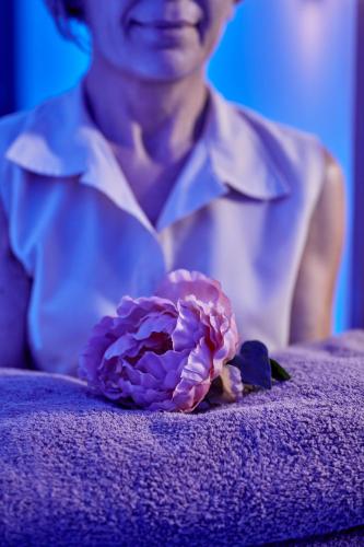a person holding a pink flower on a purple couch at Grecian Park in Protaras