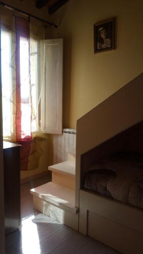 a bedroom with a bed and a window and stairs at Ulivo Della Querce in Querce