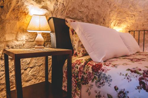 a bed with a pillow and a table with a lamp at Materiis in Noci