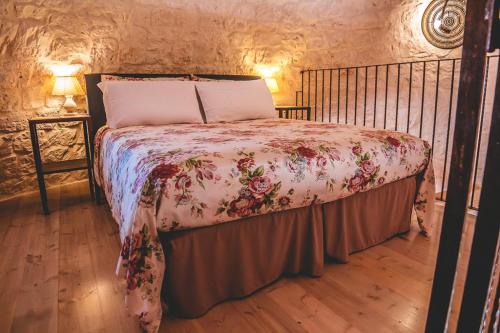 a bedroom with a bed with a floral bedspread at Materiis in Noci