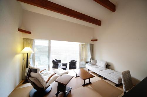 a living room with white furniture and a large window at Four Seasons Yuzawa Quattro in Yuzawa
