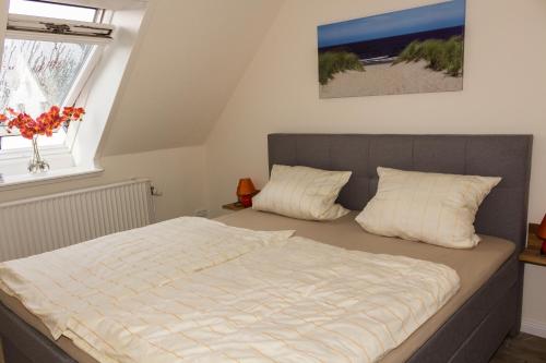 a bedroom with a bed and a window at Gästehaus Margareth in Büsum