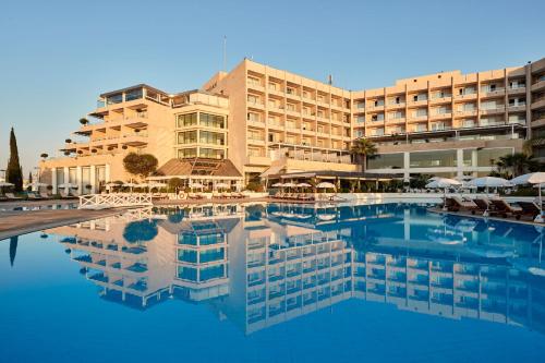a hotel with a pool in front of a building at Grecian Park in Protaras