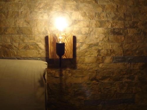 a light on a brick wall with a candle at Villa Anastasia in Pefki