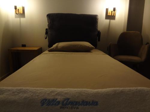 a bed with a pillow and a chair in a room at Villa Anastasia in Pefki