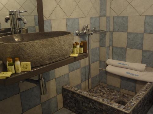 a bathroom with a stone sink and towels at Villa Anastasia in Pefki