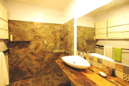 a bathroom with a sink and a large shower at Boulevard Inn Mt Meru in Arusha