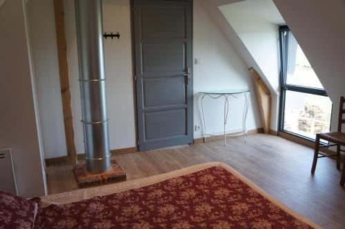 a living room with a door and a rug on the floor at Gîte l'Atelier in Lecelles