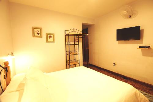 a bedroom with a bed and a television on the wall at Boulevard Inn Mt Meru in Arusha