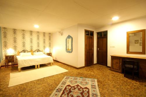 a bedroom with a bed and a room with a tv at Boulevard Inn Mt Meru in Arusha