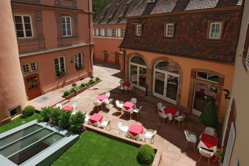 eine Luftansicht auf einen Innenhof mit Tischen und Stühlen in der Unterkunft Hôtel & Spa Le Bouclier D'or in Straßburg