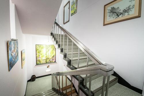 a staircase in a house with paintings on the wall at Twins Hotel in Jeju