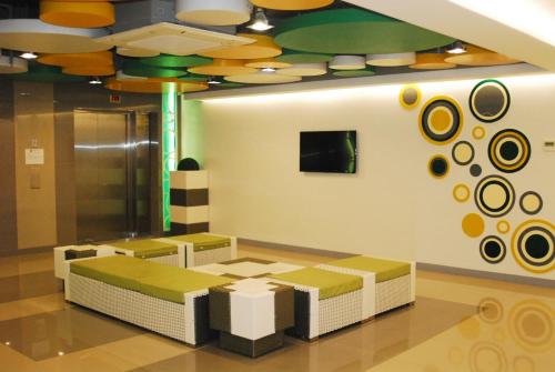 uma sala de espera com dois bancos e um tecto em Go Hotels Ortigas Center em Manila
