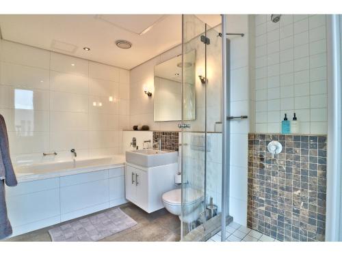 a bathroom with a toilet and a sink and a shower at Cartwrights Studio 1008 in Cape Town