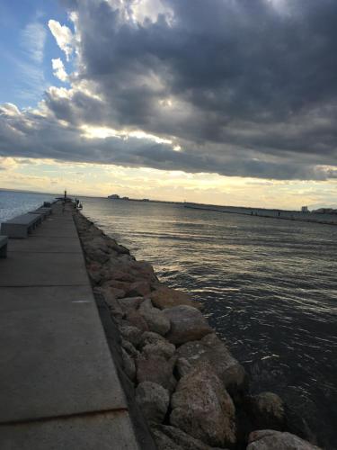 a walkway leading into the water under a cloudy sky at Apartaments El Cine in Roses