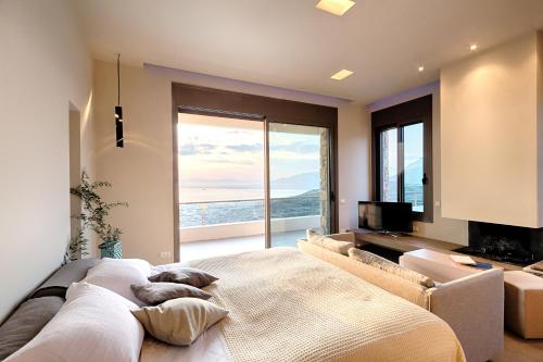 a bedroom with a large bed and a large window at Euphoria Suites in Avia