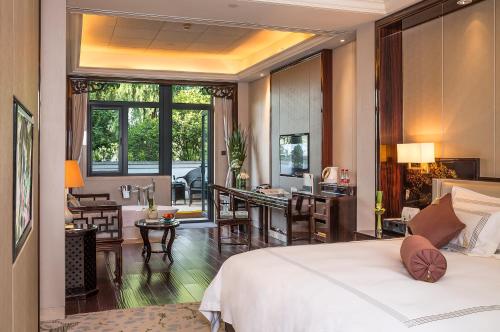 a hotel room with a bed and a living room at Zhejiang Xizi Hotel in Hangzhou