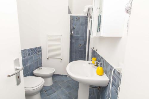 a white bathroom with a sink and a toilet at B&B del Massimo in Palermo