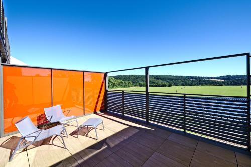 a balcony with chairs and a view of a golf course at Domaine de Naxhelet in Wanze