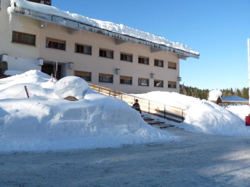 a pile of snow in front of a building at Rifugio Di Pace in Folgaria