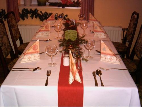 a long table with a white table cloth and wine glasses at Hotel Marianne und Restaurant Kiek In in Plau am See