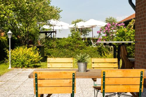 a wooden table and two chairs sitting next to a table at Hotel Marianne und Restaurant Kiek In in Plau am See