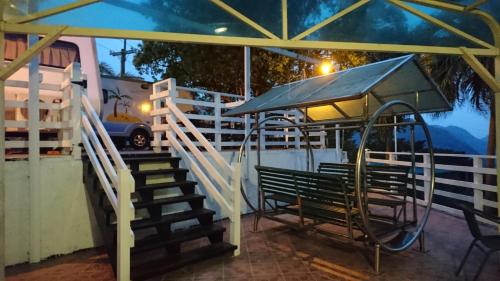 a bench with an umbrella at a bus stop at In Bali Inn in Luofu