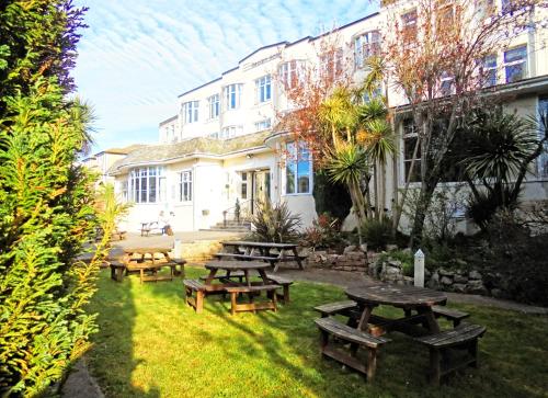a group of picnic tables in front of a building at Trecarn Hotel in Torquay