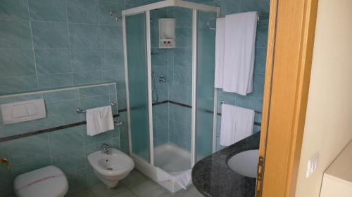 a bathroom with a shower and a toilet and a sink at King's House Hotel Resort in Mascali
