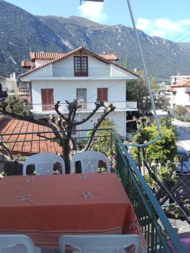 a table and chairs on a balcony with a house at Hotel Fotini in Kamena Vourla