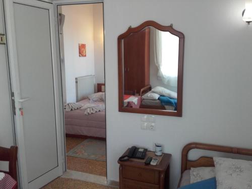 a room with a mirror and a bedroom with a bed at Hotel Fotini in Kamena Vourla