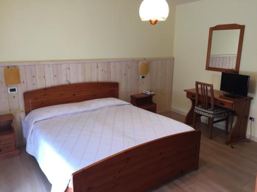 Schlafzimmer mit einem Bett, einem Schreibtisch und einem Spiegel in der Unterkunft Al Garibaldino in Posina
